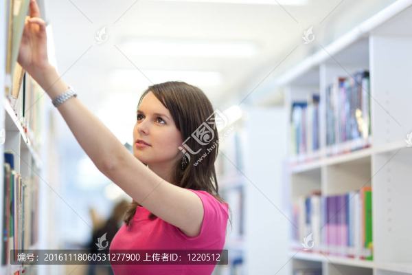 年輕漂亮的大學生在圖書館（淺景深；顏色色調的圖像）
