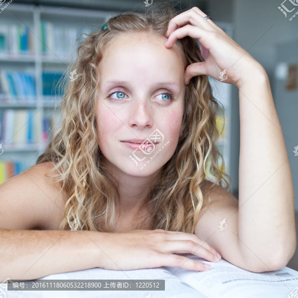 漂亮的憂郁的女大學生在圖書館