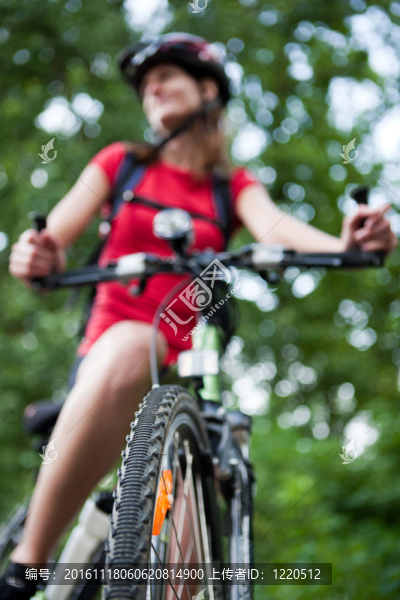 年輕漂亮的女車(chē)手outddors她的山地自行車(chē)（淺景深；選擇性聚焦）
