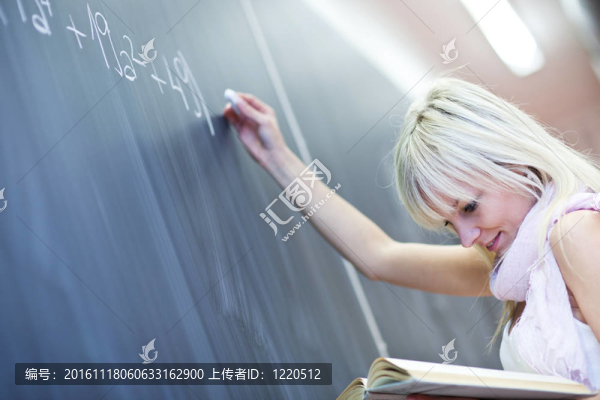 年輕漂亮的大學(xué)生寫在黑板上/黑板上數(shù)學(xué)課中