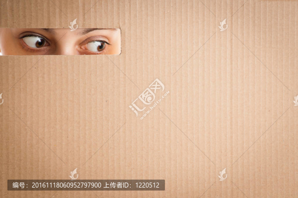 女人透過紙板孔看
