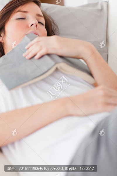 年輕迷人的女性在客廳的沙發(fā)上休息和看書