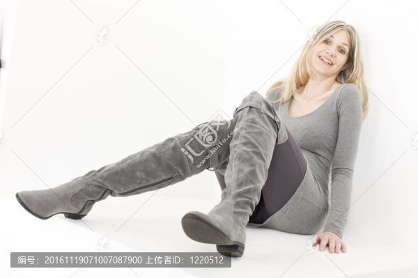 坐著的女人穿著時髦的灰色靴子
