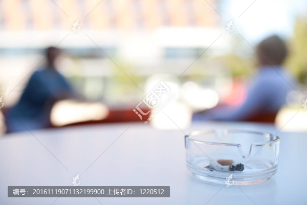 skoking在公共場所的概念，對咖啡的人陽臺的煙灰缸特寫（非吸煙者）的背景