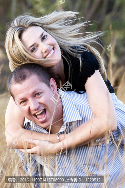 年輕性感美麗的金發(fā)夫婦在夏天在長草上抱著笑