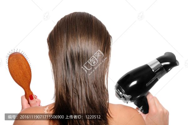 用吹風(fēng)機(jī)和毛刷的年輕女子