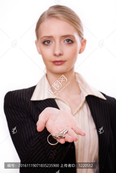 女人手上拿著一把新鑰匙，指著相機的照片。