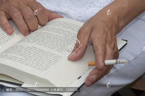 一個女人在看書的時候抽煙。