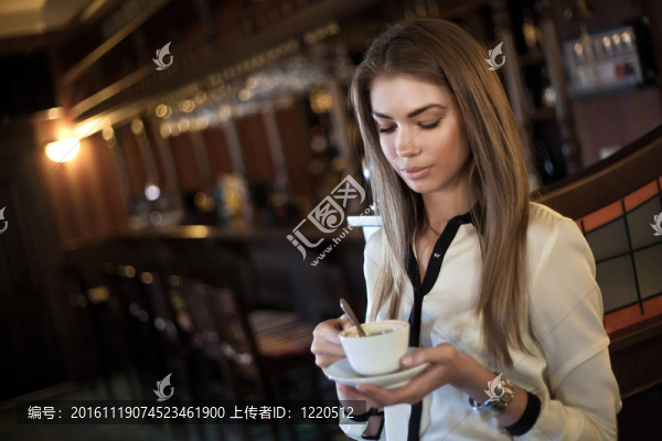 在咖啡館里喝杯咖啡的年輕漂亮女人
