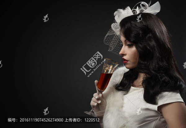 優(yōu)雅的女人拿著一杯酒。復(fù)古的畫像