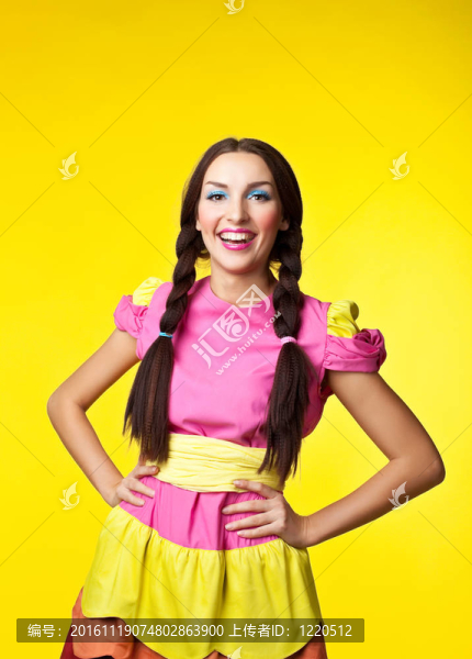 穿著洋娃娃服裝的年輕女孩在黃色上微笑