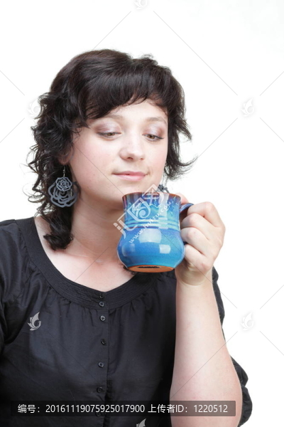女子拿著一個藍色的杯子；孤立的