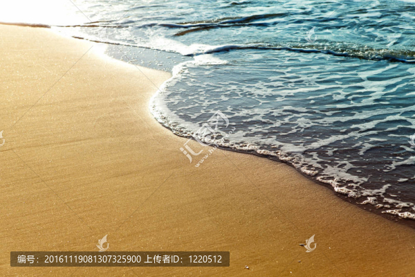 夕陽下金色沙灘上閃亮的熱帶海浪