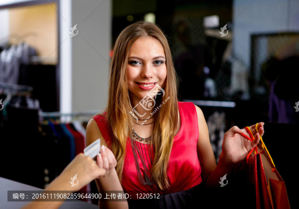 年輕的女人在一家商店買(mǎi)衣服