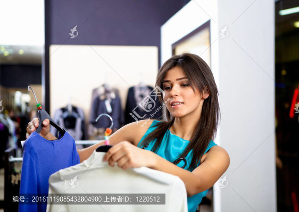 年輕的女人在一家商店買衣服
