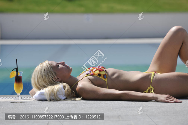 美麗的女人在游泳池放松