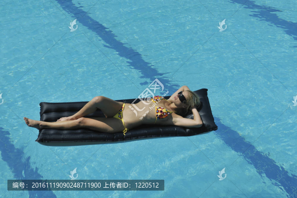 美麗的女人在游泳池放松