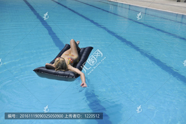 美麗的女人在游泳池放松