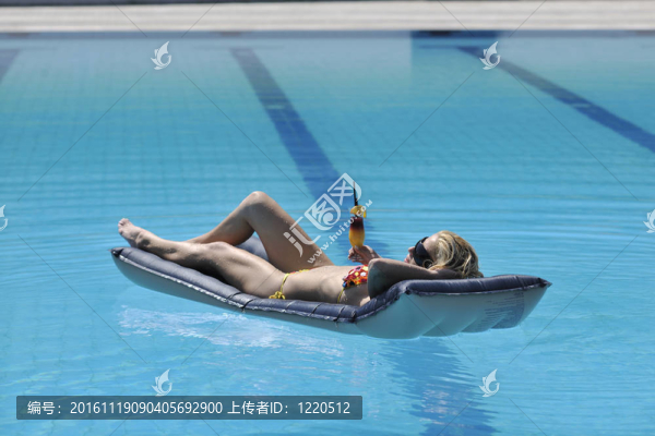 美麗的女人在游泳池放松