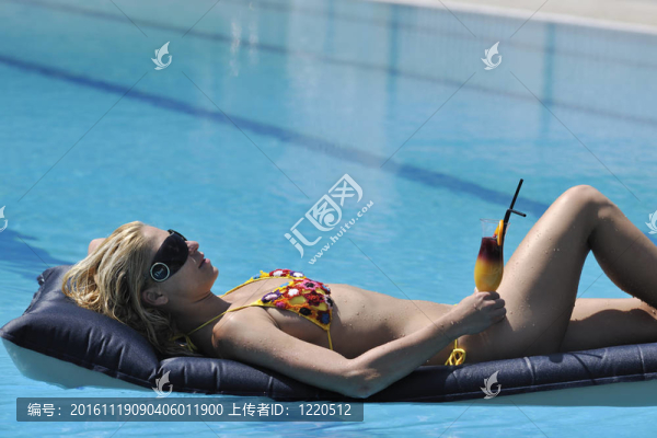 美麗的女人在游泳池放松