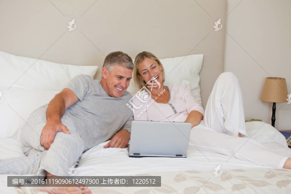 可愛(ài)的一對(duì)夫婦在看他們的筆記本電腦