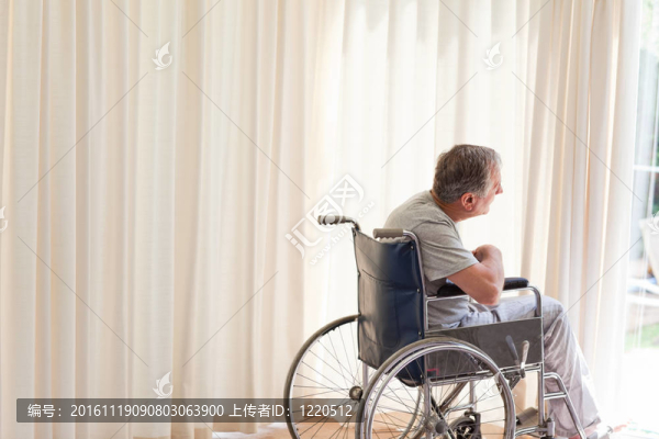 坐在輪椅上的男人望著窗外