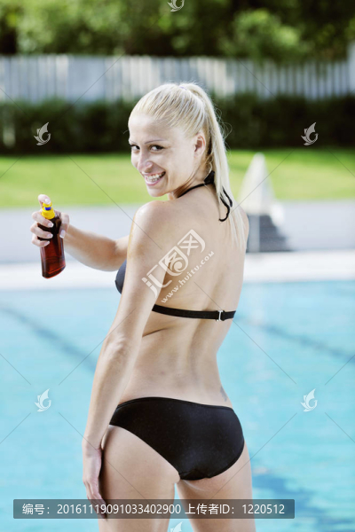 美麗的女人在游泳池放松