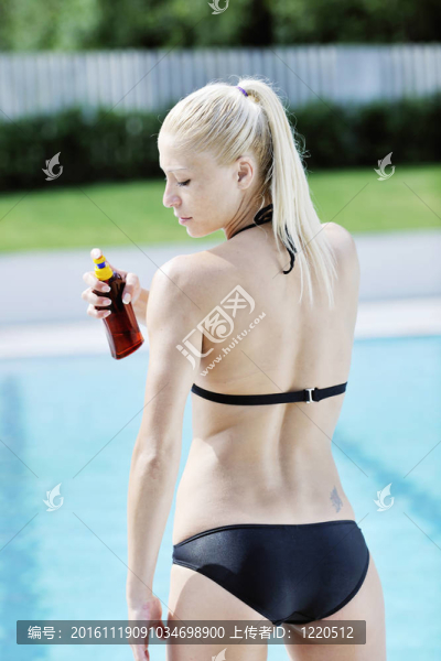 美麗的女人在游泳池放松