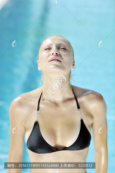 美麗的女人在游泳池放松