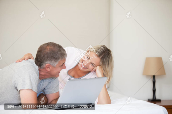 可愛的夫婦看著他們的筆記本