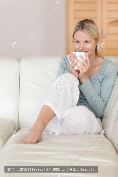 女人在沙發(fā)上呷了一口咖啡