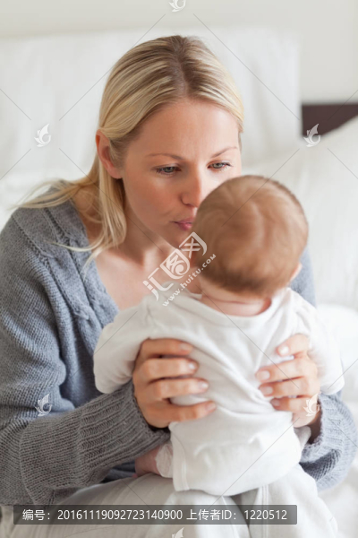 嬰兒坐在母親的腿上