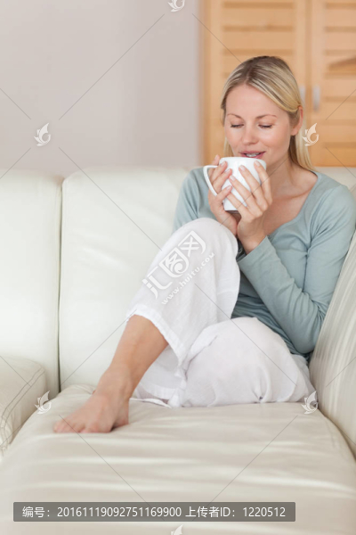 沙發(fā)上的女人呷了一口咖啡