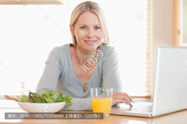 在筆記本上工作的女人吃健康午餐