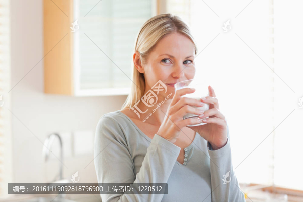 站在廚房里喝水的女人