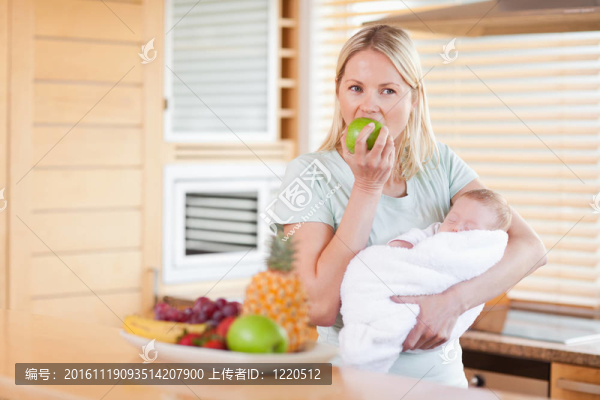 抱著嬰兒吃蘋果的婦女