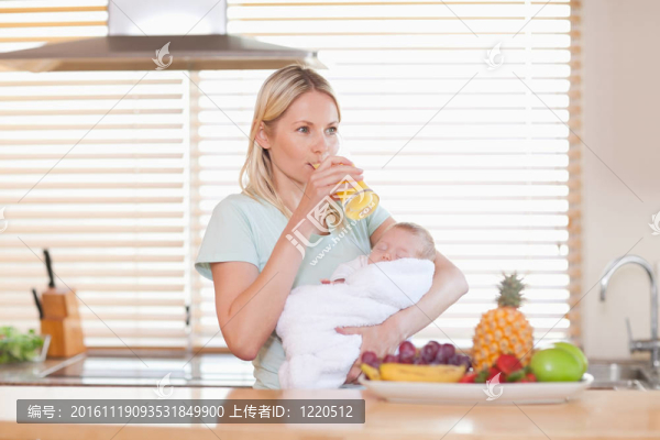 女人抱著嬰兒呷了一口果汁
