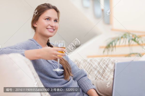 女人在使用筆記本時(shí)喝了一杯酒