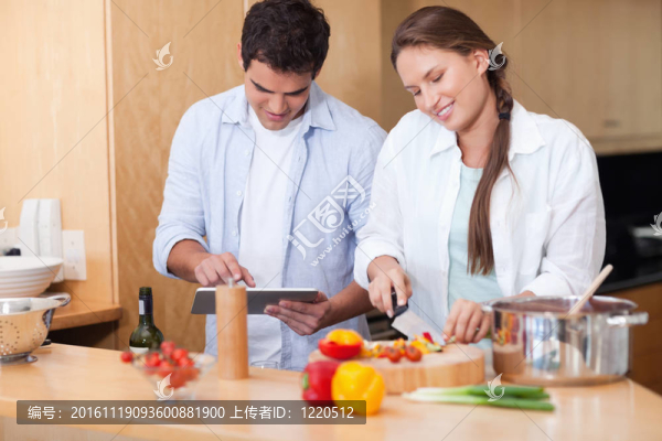 夫婦使用平板電腦做飯