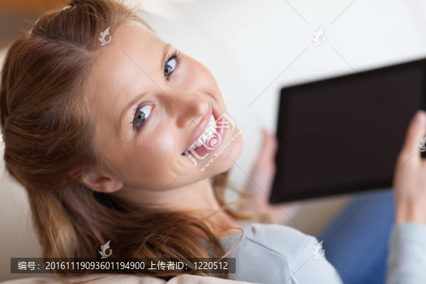 沙發(fā)上的微笑女人與平板