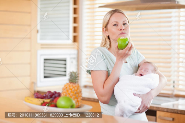 女人咬著蘋果抱著嬰兒