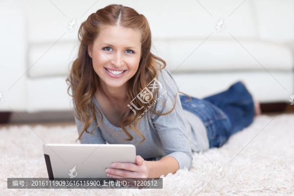 微笑的女人在地板上使用她的藥片