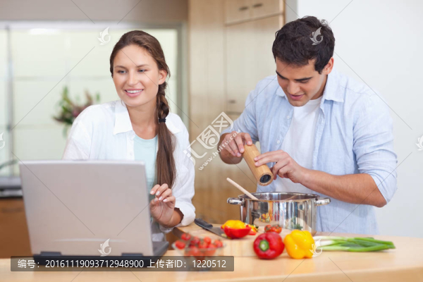 年輕夫婦用筆記本做飯