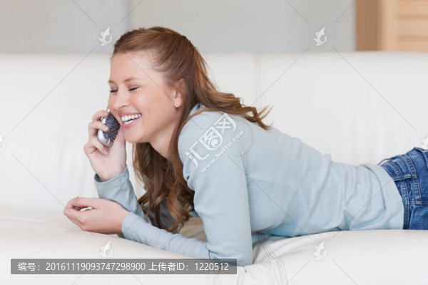 年輕的女人在笑著打電話