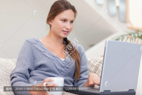 女人在喝咖啡的時候用筆記本電腦