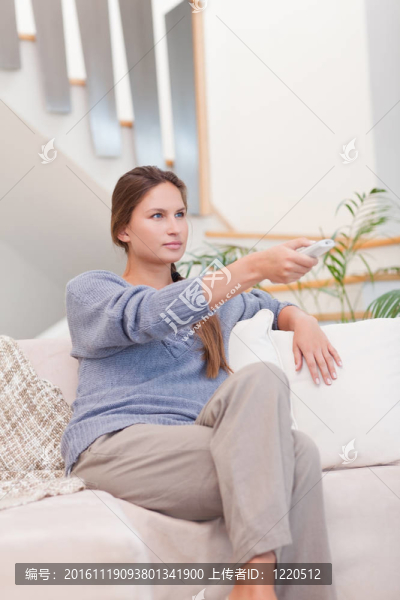 女人用遙控器切換頻道的肖像