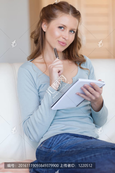 女人在沙發(fā)上用筆和記事本