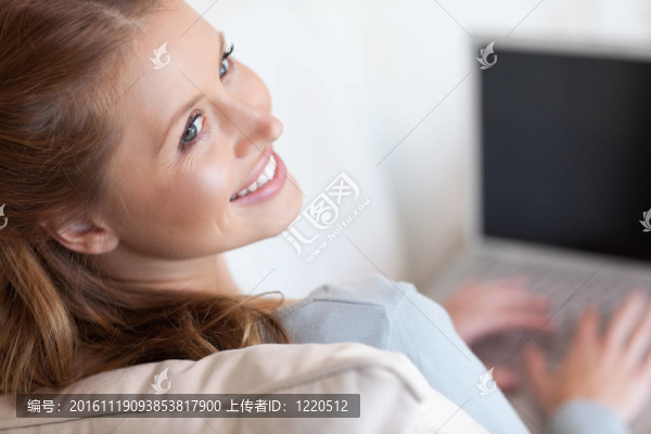 微笑的女人在她的筆記本電腦上工作