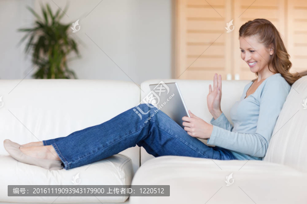 笑著的女人把筆記本放在沙發(fā)上