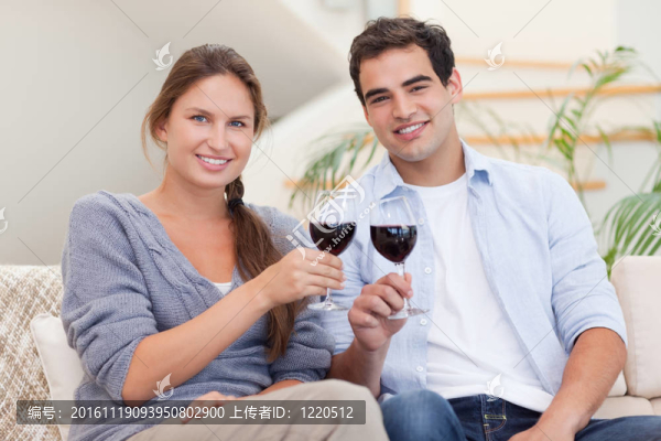 一對(duì)年輕夫婦有一杯紅葡萄酒